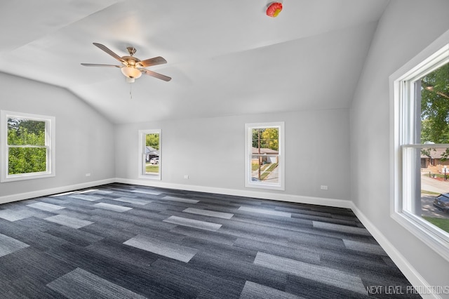 interior space with ceiling fan, dark colored carpet, and lofted ceiling