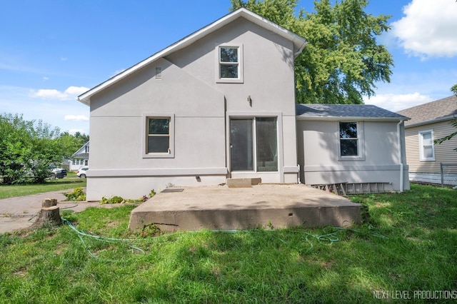 rear view of property with a patio, a lawn, and stucco siding