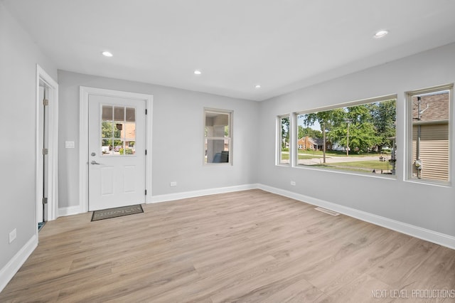 foyer entrance with a wealth of natural light, light wood-style flooring, baseboards, and recessed lighting