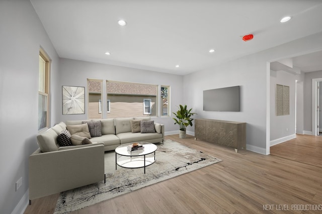 living area featuring baseboards, wood finished floors, and recessed lighting