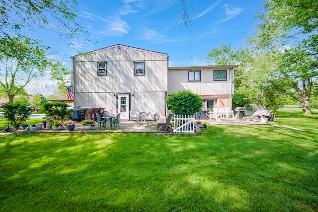 rear view of house featuring a patio area and a yard