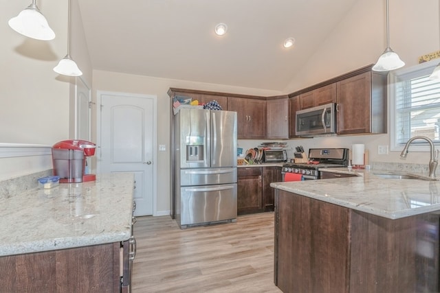 kitchen featuring sink, light stone countertops, hanging light fixtures, and appliances with stainless steel finishes