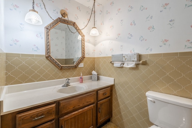 bathroom with vanity, tile walls, and toilet