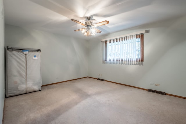 empty room with ceiling fan and light colored carpet