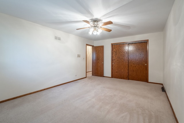 unfurnished bedroom featuring a closet, ceiling fan, and light colored carpet