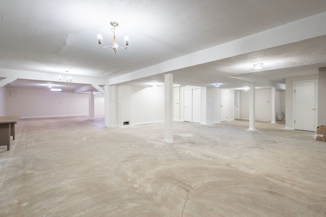 basement featuring a textured ceiling and a notable chandelier