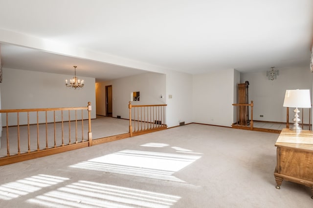 unfurnished room with carpet floors and a notable chandelier