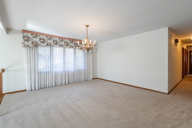 carpeted empty room with an inviting chandelier