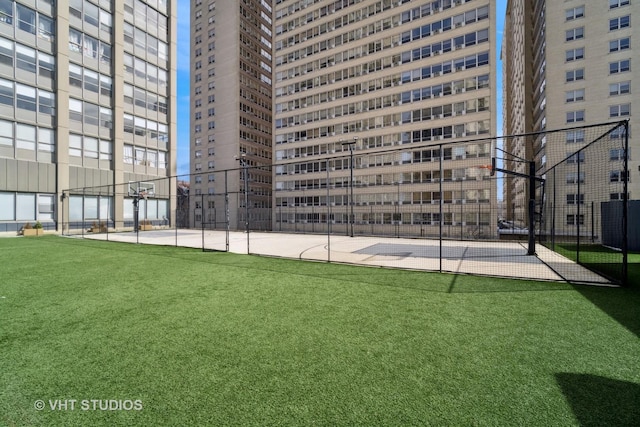 exterior space with a lawn, fence, and community basketball court