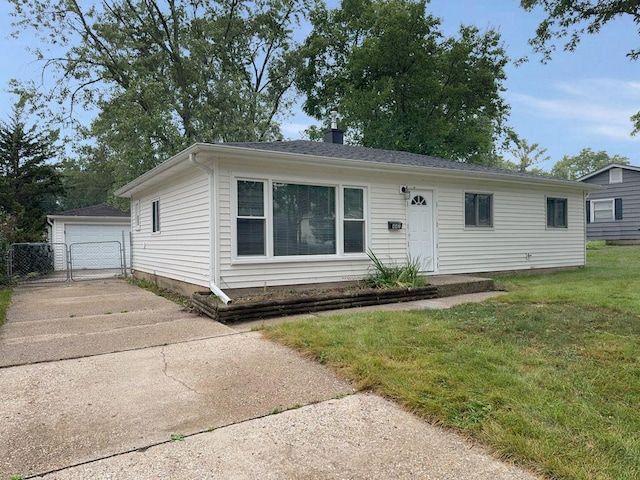 view of front of home with an outbuilding, a garage, and a front lawn