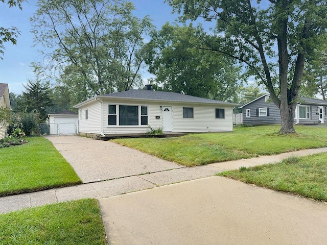 view of front facade featuring a front yard, a garage, and an outdoor structure