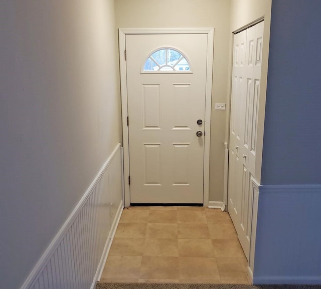 carpeted foyer entrance with a wealth of natural light and wood walls