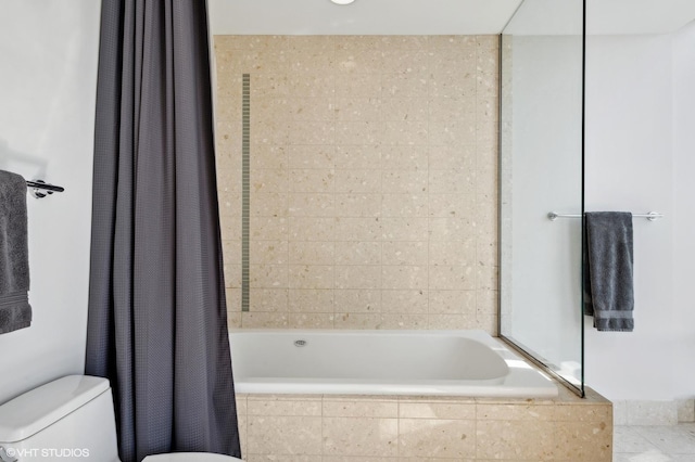 bathroom with toilet and tiled shower / bath