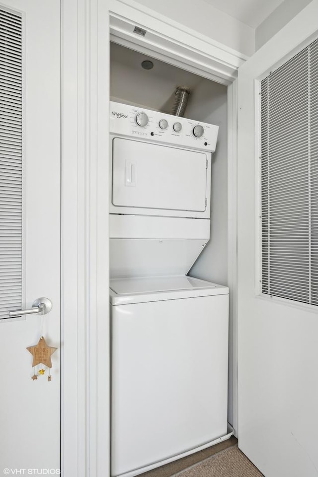 clothes washing area featuring laundry area and stacked washer / drying machine