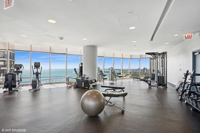 exercise room with a wall of windows, recessed lighting, a water view, and visible vents