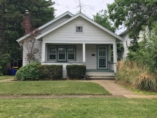 view of front of house with covered porch and a front lawn