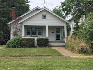 bungalow with a porch and a front yard