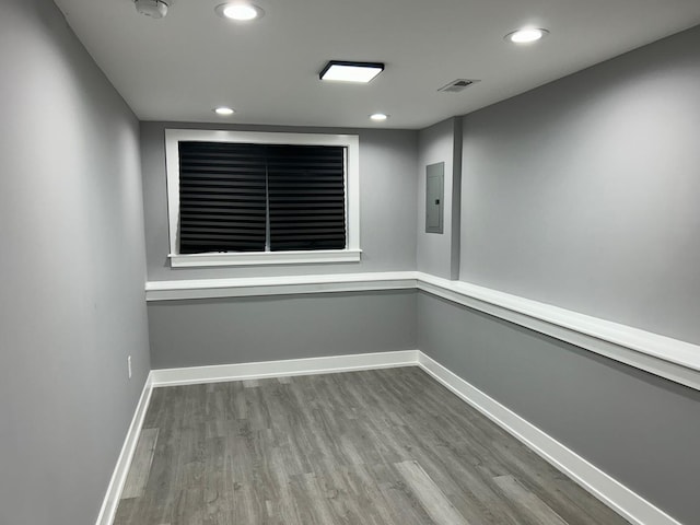 empty room with hardwood / wood-style flooring and electric panel