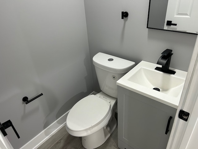 bathroom featuring toilet, vanity, and wood-type flooring