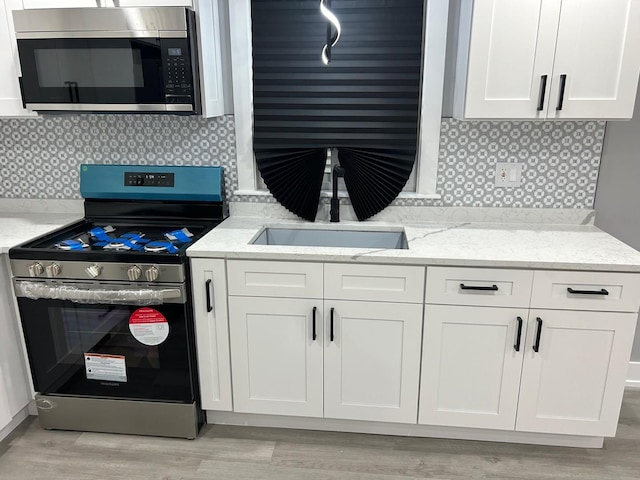 kitchen featuring sink, white cabinets, and appliances with stainless steel finishes