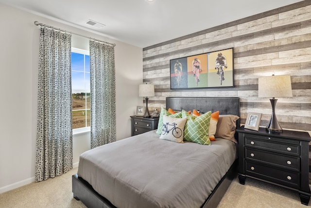 bedroom with light carpet and wood walls