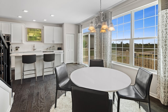 dining space with an inviting chandelier, sink, and dark hardwood / wood-style flooring