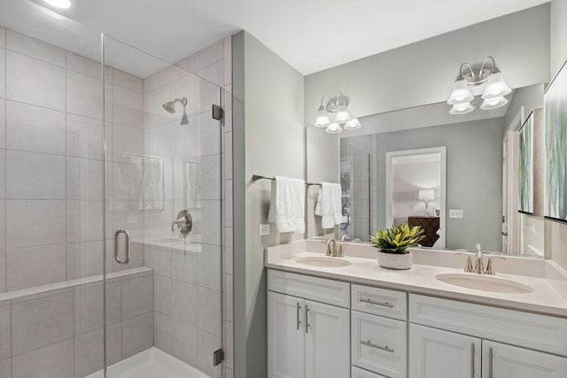 bathroom featuring vanity, an inviting chandelier, and a shower with shower door