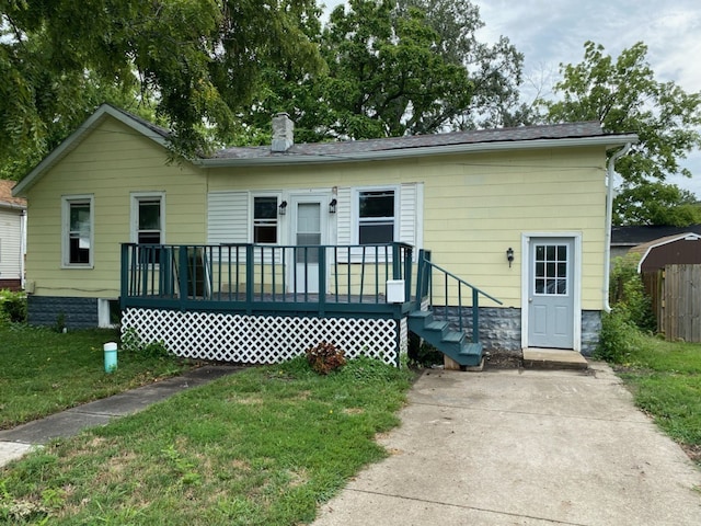 view of front facade with a chimney and a front yard