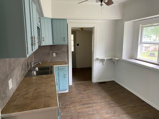 kitchen featuring ceiling fan, backsplash, sink, and dark hardwood / wood-style floors