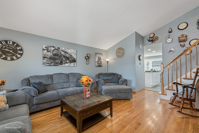 living room with light wood-type flooring and vaulted ceiling