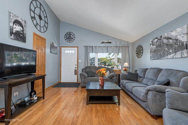 living room with light hardwood / wood-style flooring and high vaulted ceiling