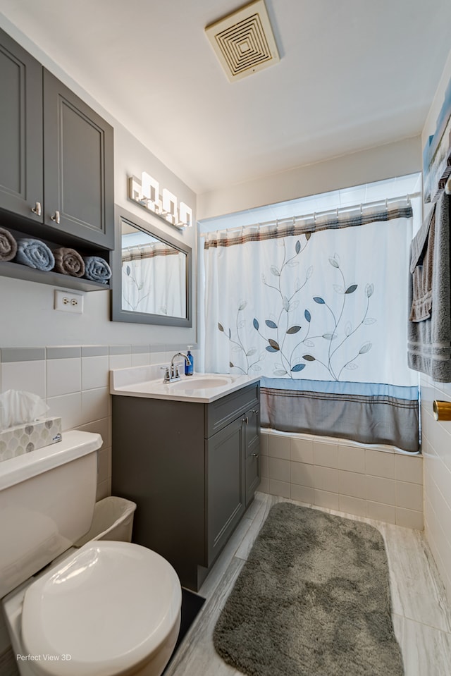 bathroom featuring tile walls, vanity, toilet, and tile patterned floors