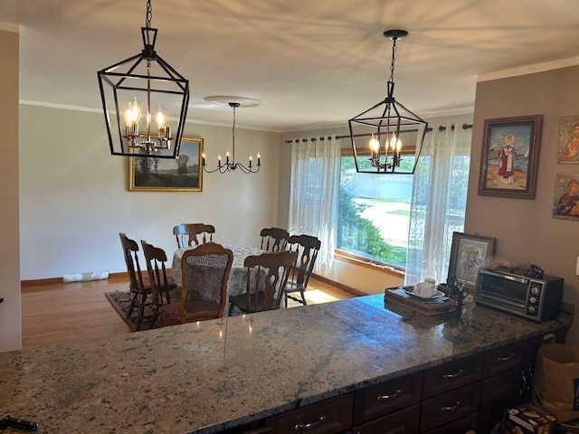 dining room with light wood-type flooring, a notable chandelier, and ornamental molding