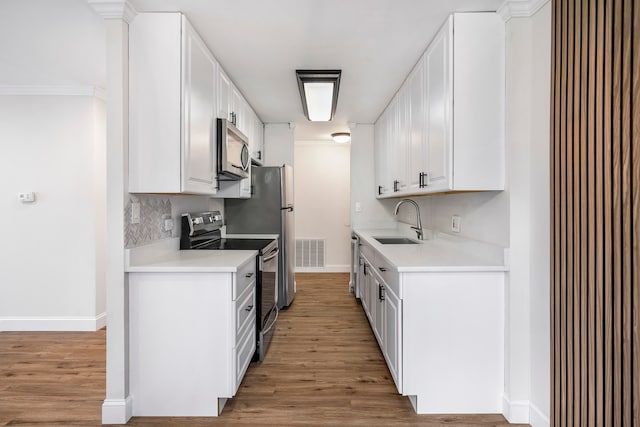 kitchen featuring sink, ornamental molding, hardwood / wood-style flooring, white cabinetry, and range with electric stovetop