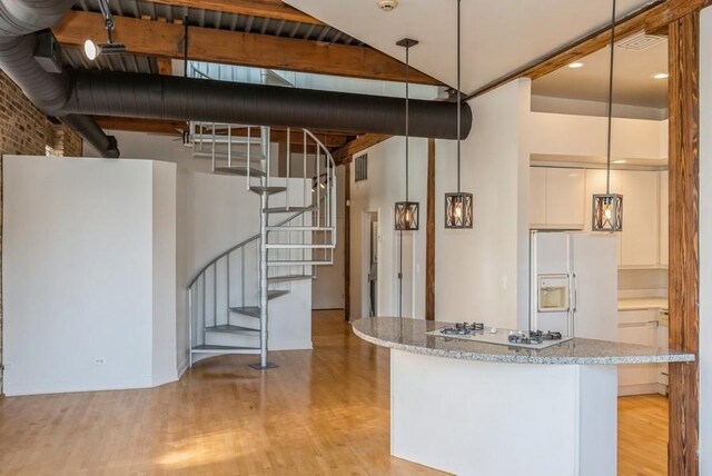 kitchen with hanging light fixtures, light hardwood / wood-style floors, and white appliances