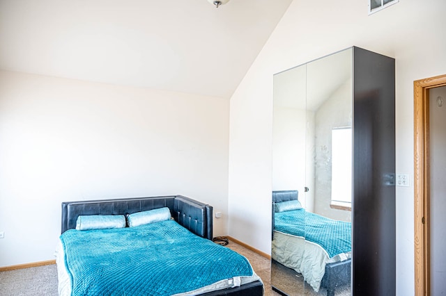 bedroom featuring light colored carpet and high vaulted ceiling