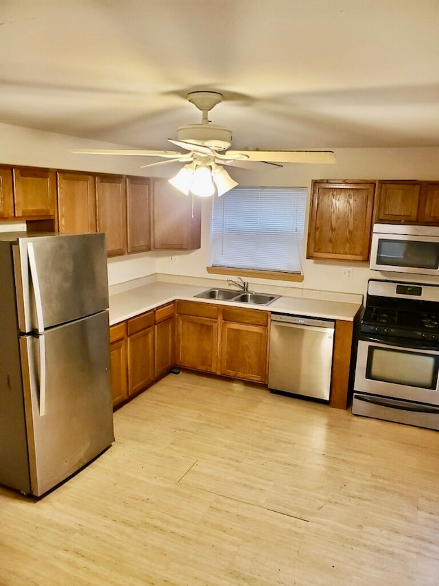 kitchen featuring ceiling fan, light hardwood / wood-style floors, appliances with stainless steel finishes, and sink