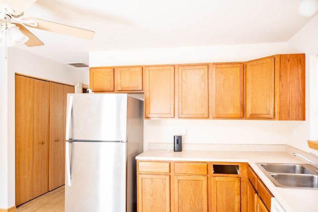 kitchen with ceiling fan, sink, stainless steel refrigerator, dishwasher, and light hardwood / wood-style floors