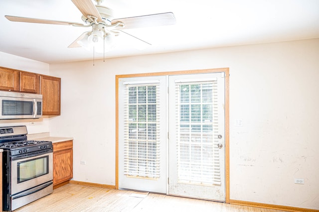 kitchen featuring ceiling fan, appliances with stainless steel finishes, and light hardwood / wood-style floors