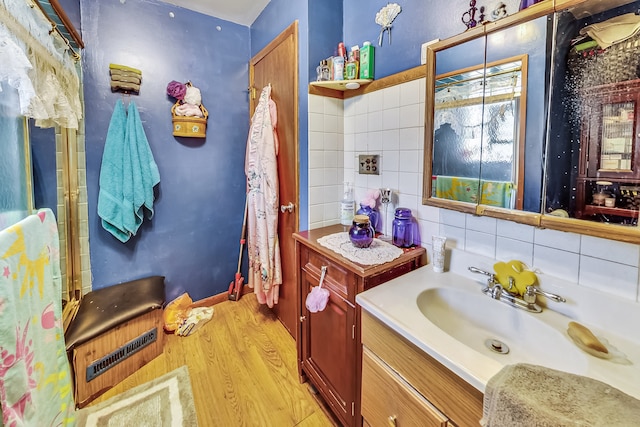 bathroom featuring decorative backsplash, vanity, and hardwood / wood-style flooring