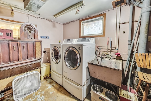 laundry area featuring washing machine and clothes dryer and sink