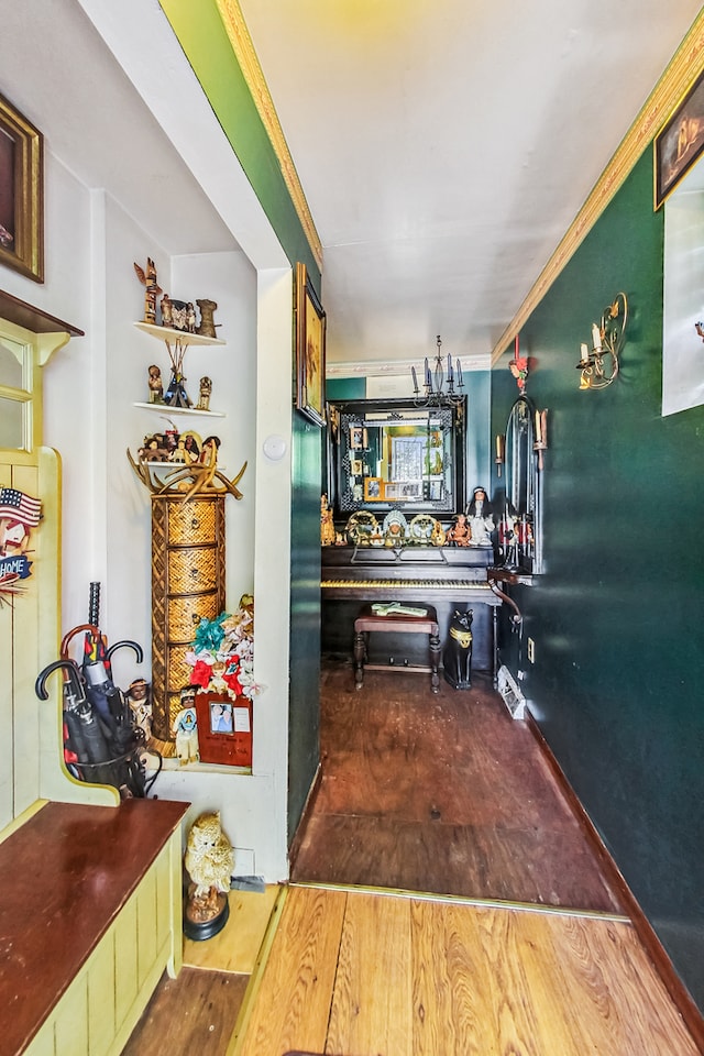 corridor with ornamental molding and hardwood / wood-style floors