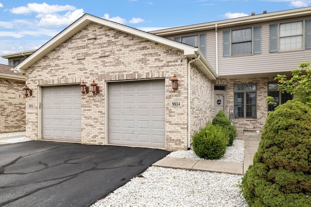 view of front of house featuring a garage, driveway, and brick siding