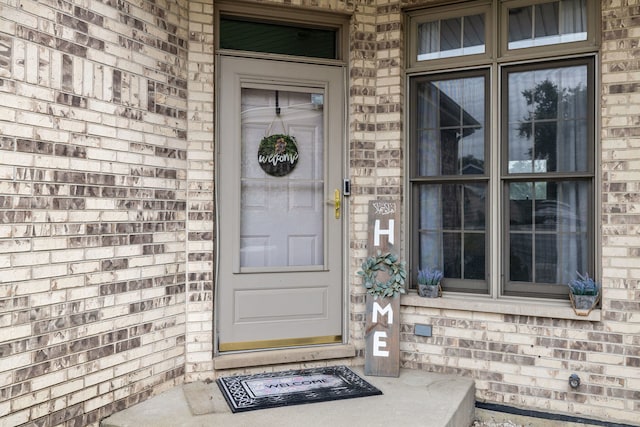 view of exterior entry featuring brick siding