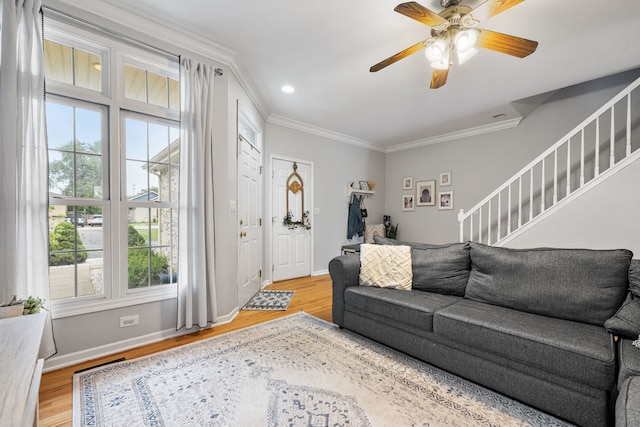 living area featuring ornamental molding, light wood-style flooring, and stairs