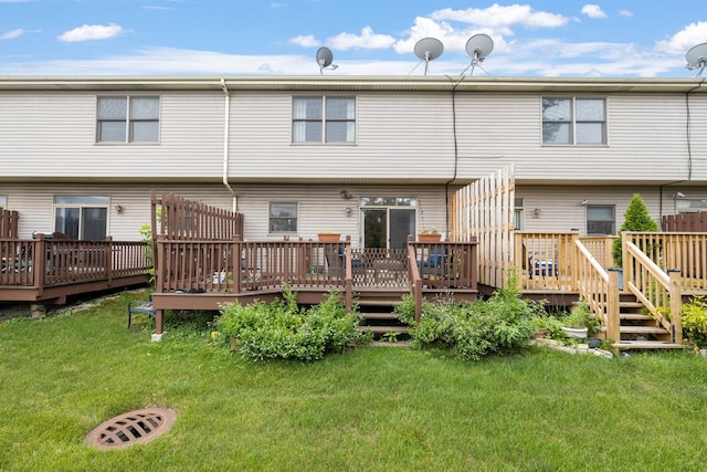 rear view of property featuring a yard and a wooden deck