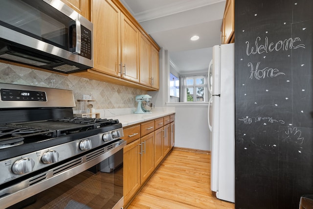 kitchen featuring appliances with stainless steel finishes, ornamental molding, light wood finished floors, and tasteful backsplash