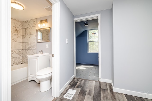 full bathroom with toilet, hardwood / wood-style floors, tiled shower / bath combo, and vanity