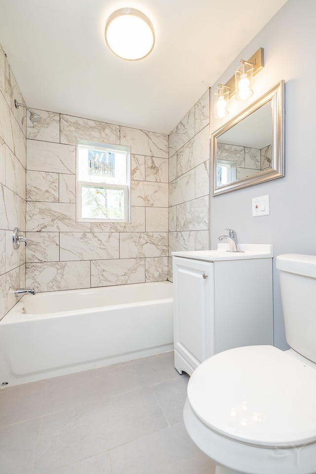 full bathroom featuring tile patterned flooring, vanity, tiled shower / bath combo, and toilet