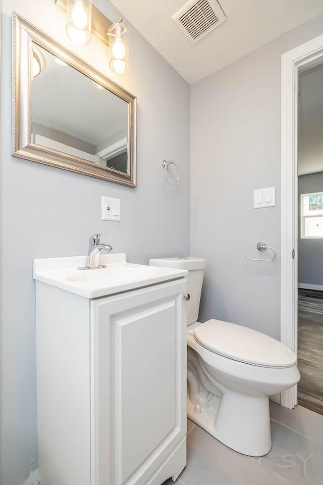 bathroom with tile patterned flooring, toilet, and vanity